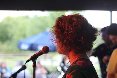 Woman singing on microphone at music concert