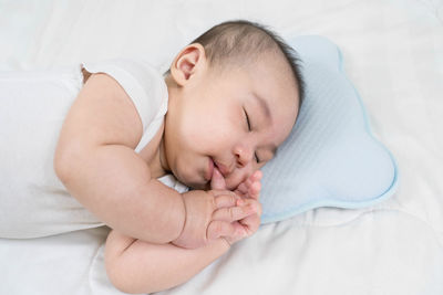 High angle view of baby sleeping on bed