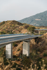 Bridge over mountains against sky