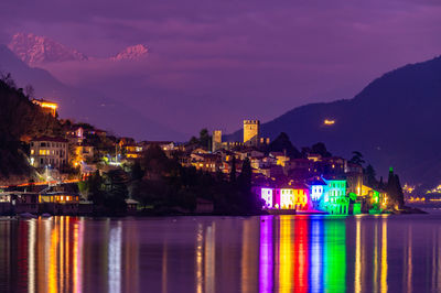 The town of santa maria rezzonico, on lake como, in the evening, with its tower and the snowy alps.