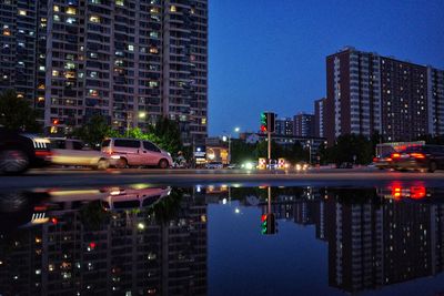 Reflection of illuminated buildings in city at night