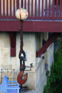 Close-up of chain hanging on railing against building