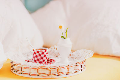 Coffee with eggcup in wicker basket on table