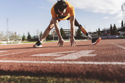 Athlete with prosthetic leg exercising on running track
