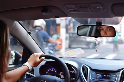 Reflection of woman in car mirror