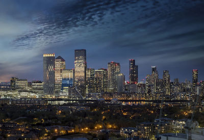 Illuminated buildings in city against sky at night