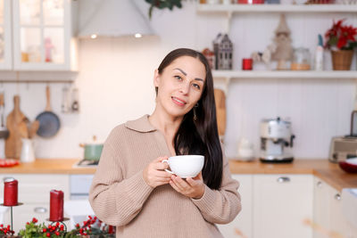 Concept festive christmas atmosphere, cute woman drinking tea or coffee