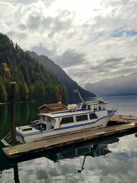 Boats moored on lake against sky