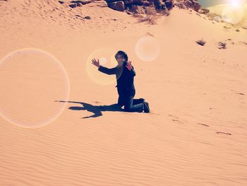 Full length of man playing soccer on sand