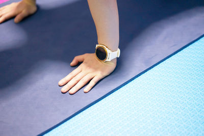 Hands on mat floor with sport monitor watch in training exercise fitness session,high angle view