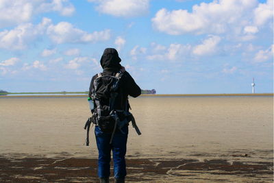 Rear view of person on beach against sky