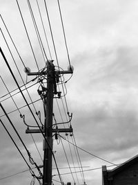 Low angle view of electricity pylon against sky