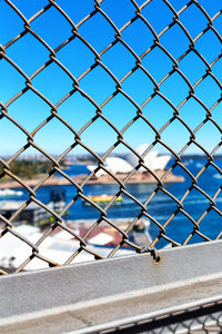 Close-up of chainlink fence against blue sky