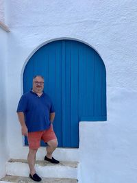 Portrait of man standing against wall