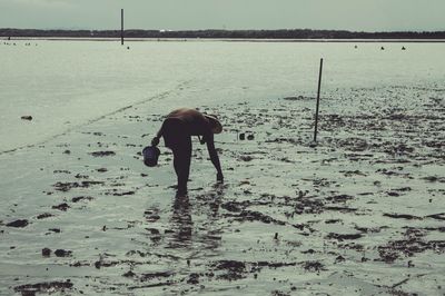 Full length of a young man standing on beach