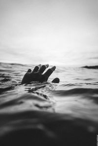 Close-up of swimming in sea against sky
