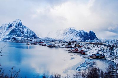 Townscape by lake against snowcapped mountains