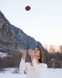 Young woman standing on snow against mountain