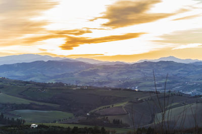 Scenic view of landscape and mountains against sky during sunset