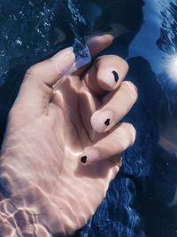Cropped image of woman hand in water