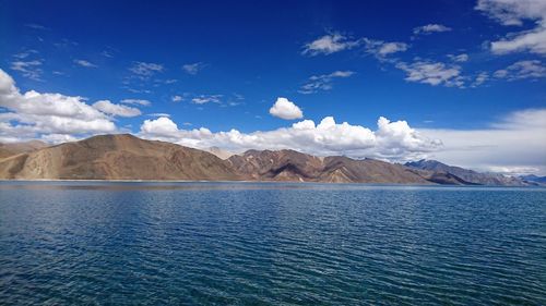 Scenic view of lake and mountains against blue sky