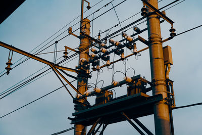 Low angle view of electricity pylon against sky