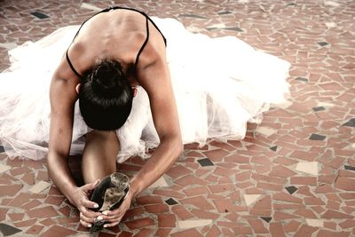 Woman dancing while sitting on floor