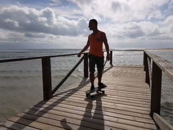 Full length of man standing on jetty against sea