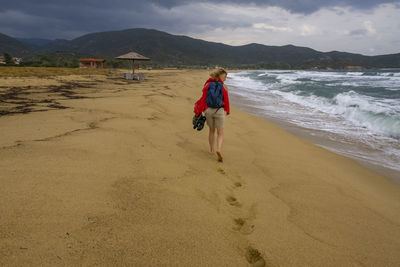 Rear view of woman walking at beach