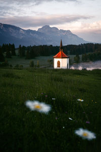Traditional windmill on field by mountains against sky