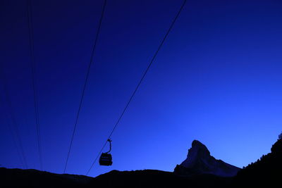 Low angle view of overhead cable car against sky