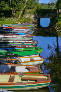 Stack of boats in lake against trees