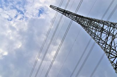 Low angle view of ferris wheel against cloudy sky