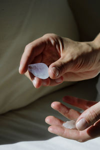 Hand holding crystal against dark background