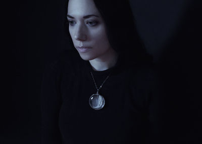 Portrait of a beautiful young woman over black background