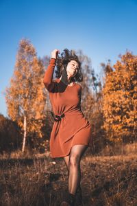 Woman with eyes closed dancing on field during autumn