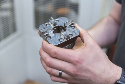 Close-up of man holding workpiece in factory