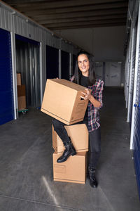 Portrait of smiling young woman holding camera in box