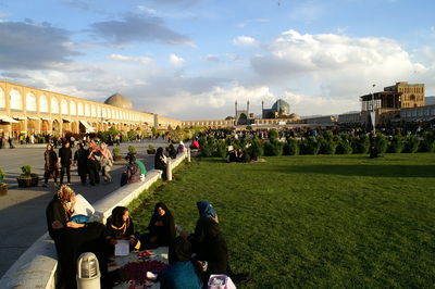 Group of people in city against sky