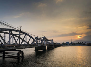 Bridge over river against sky during sunset