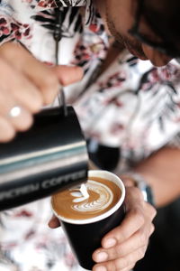 Cropped image of hand holding coffee cup