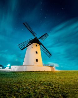 Traditional windmill on field against sky