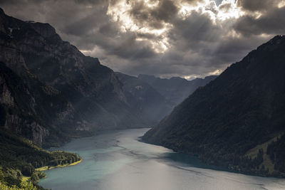 Scenic view of lake and mountains against cloudy sky