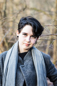 Portrait of young woman against dry plants