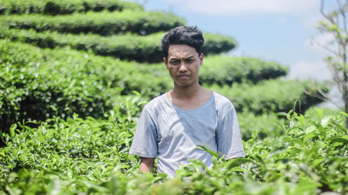 Portrait of young man standing on agriculture field