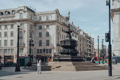 People walking on street amidst buildings in city