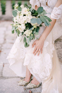 Midsection of woman holding flower bouquet