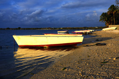 Boat moored on beach against sky