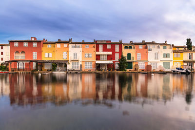 Reflection of buildings on river against sky