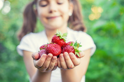 Cute girl holding strawberries